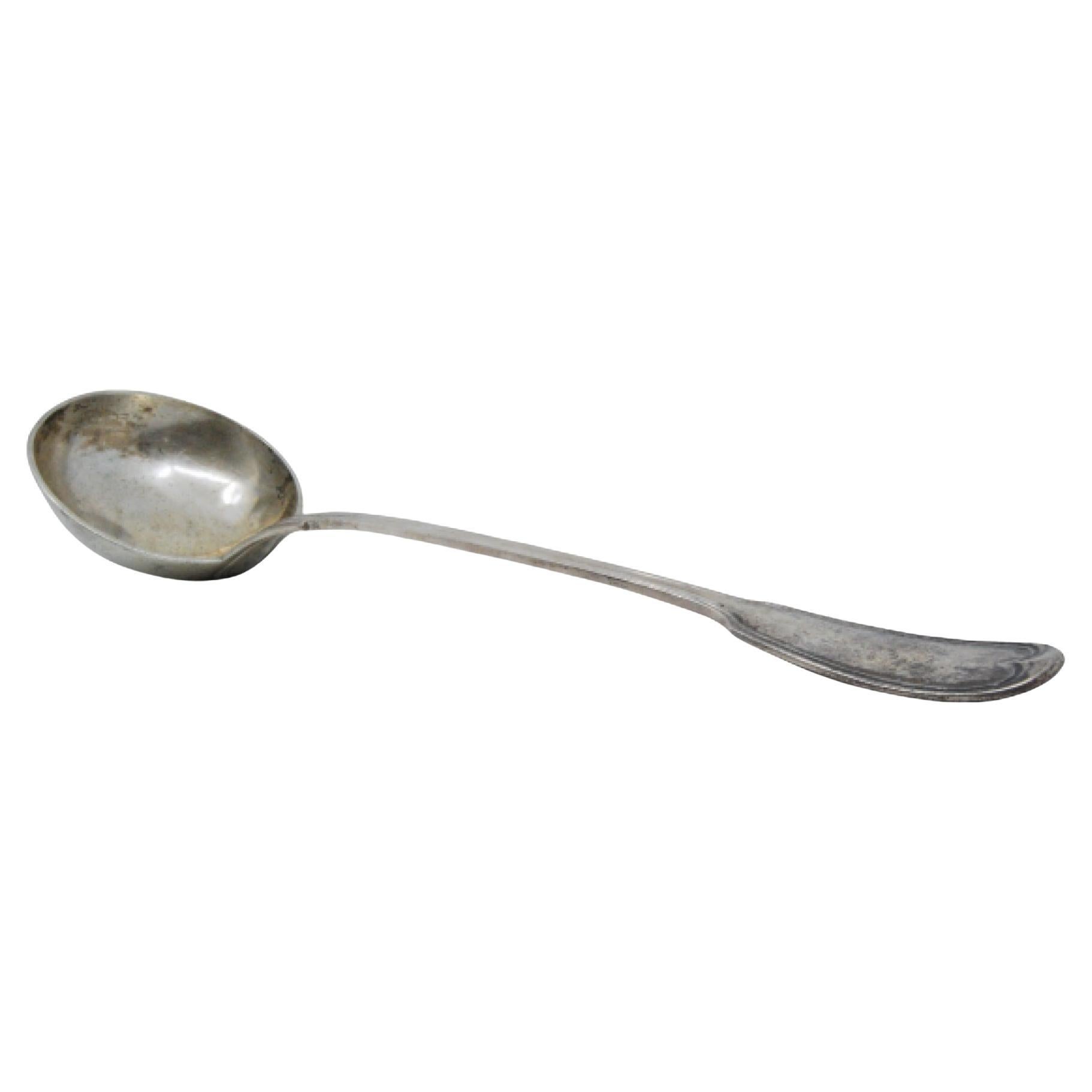Silver soup ladle with grooves along the handle