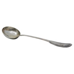 Silver soup ladle with grooves along the handle