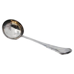 Silver soup ladle with grooves along the handle
