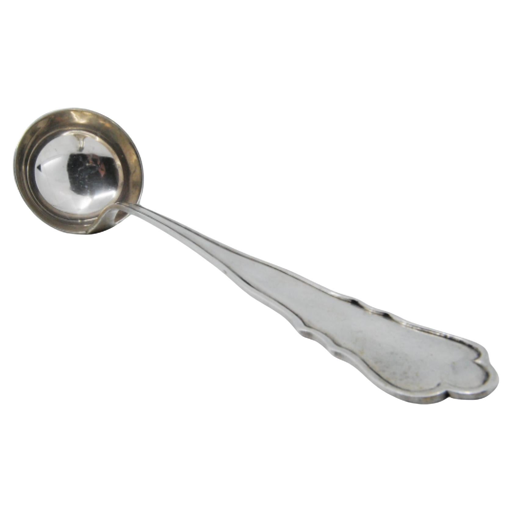 Silver soup ladle with grooves along the handle