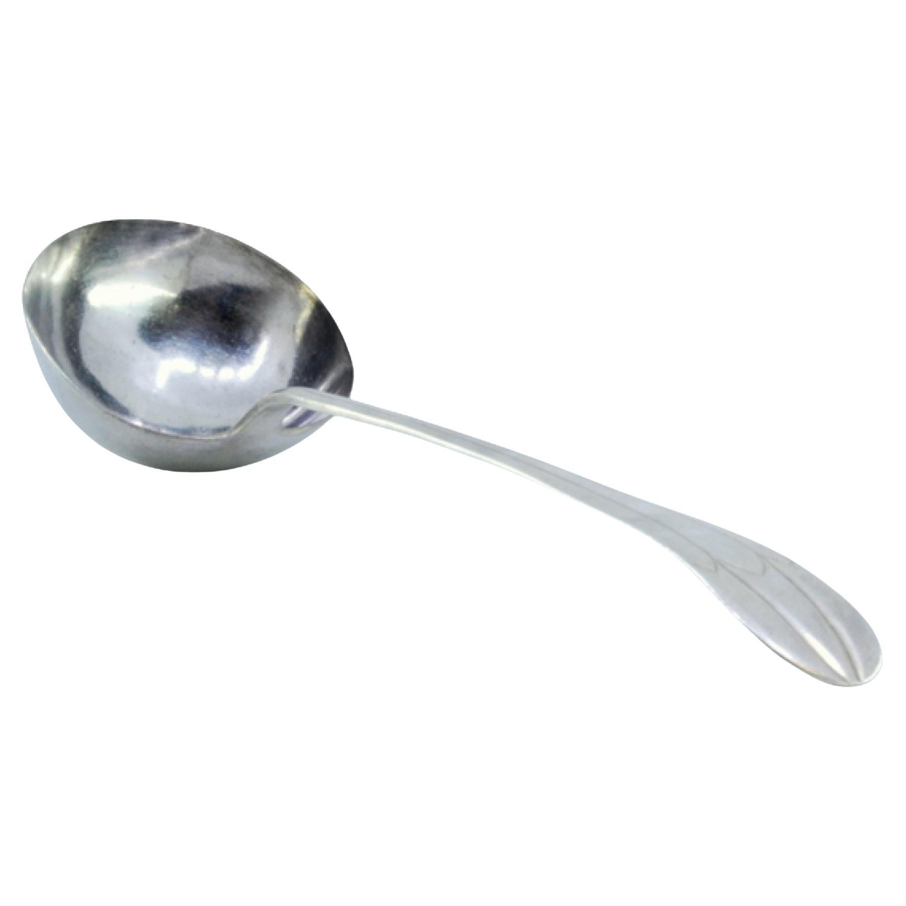 Silver soup ladle with grooves along the handle