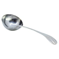 Silver soup ladle with grooves along the handle