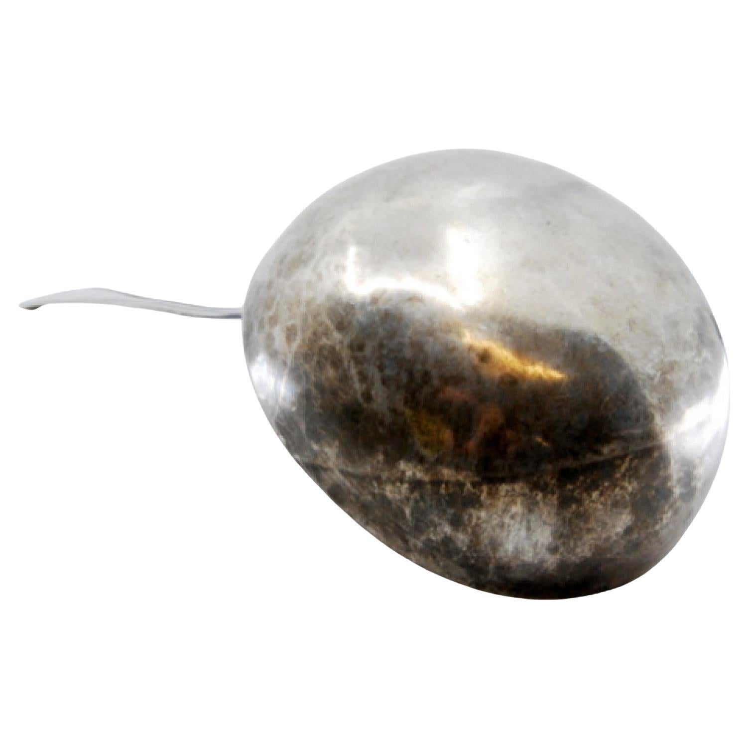 Silver soup ladle with grooves along the handle