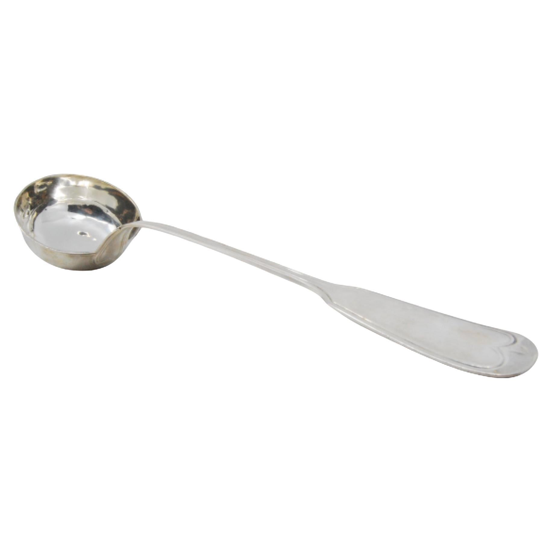 Silver soup ladle with grooves along the handle