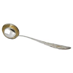 Silver soup ladle with grooves along the handle