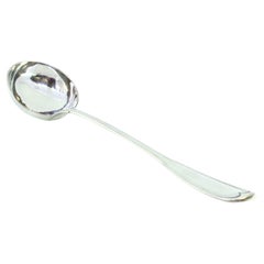Silver soup ladle with grooves along the handle to be shipped