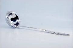 Silver soup ladle with grooves along the raised handle