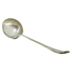 Silver soup ladle with grooves along the raised handle