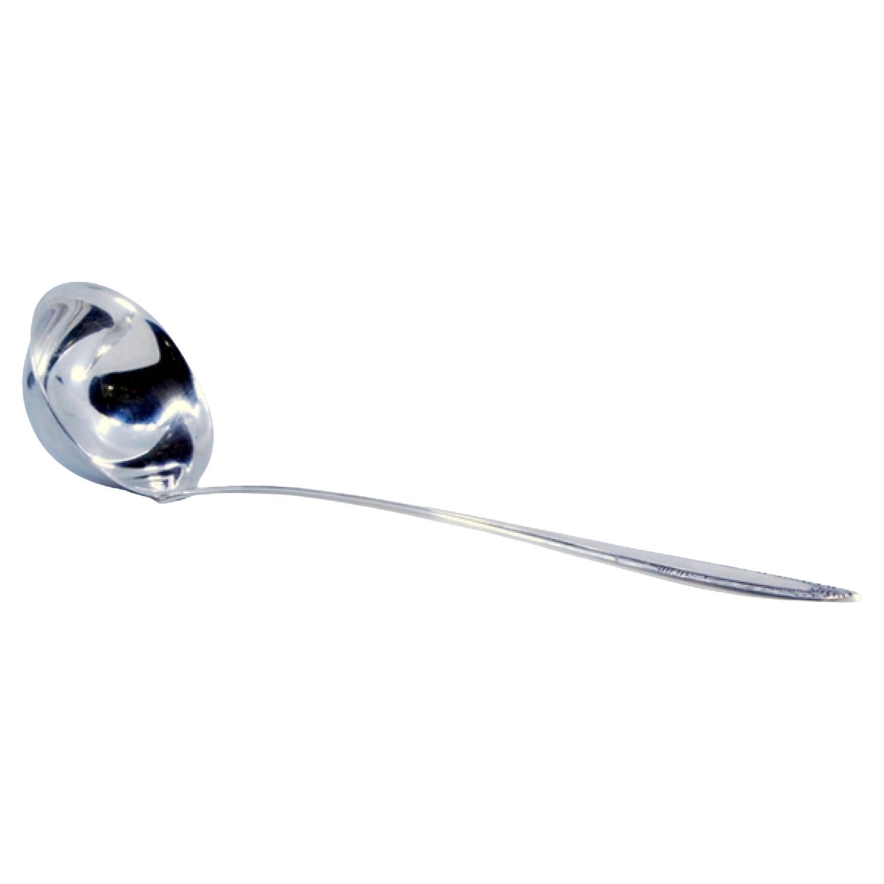 Silver soup ladle with grooves along the raised handle
