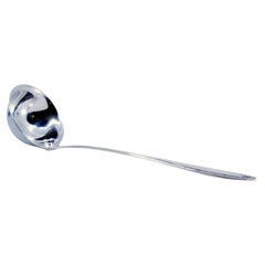 Silver soup ladle with grooves along the raised handle