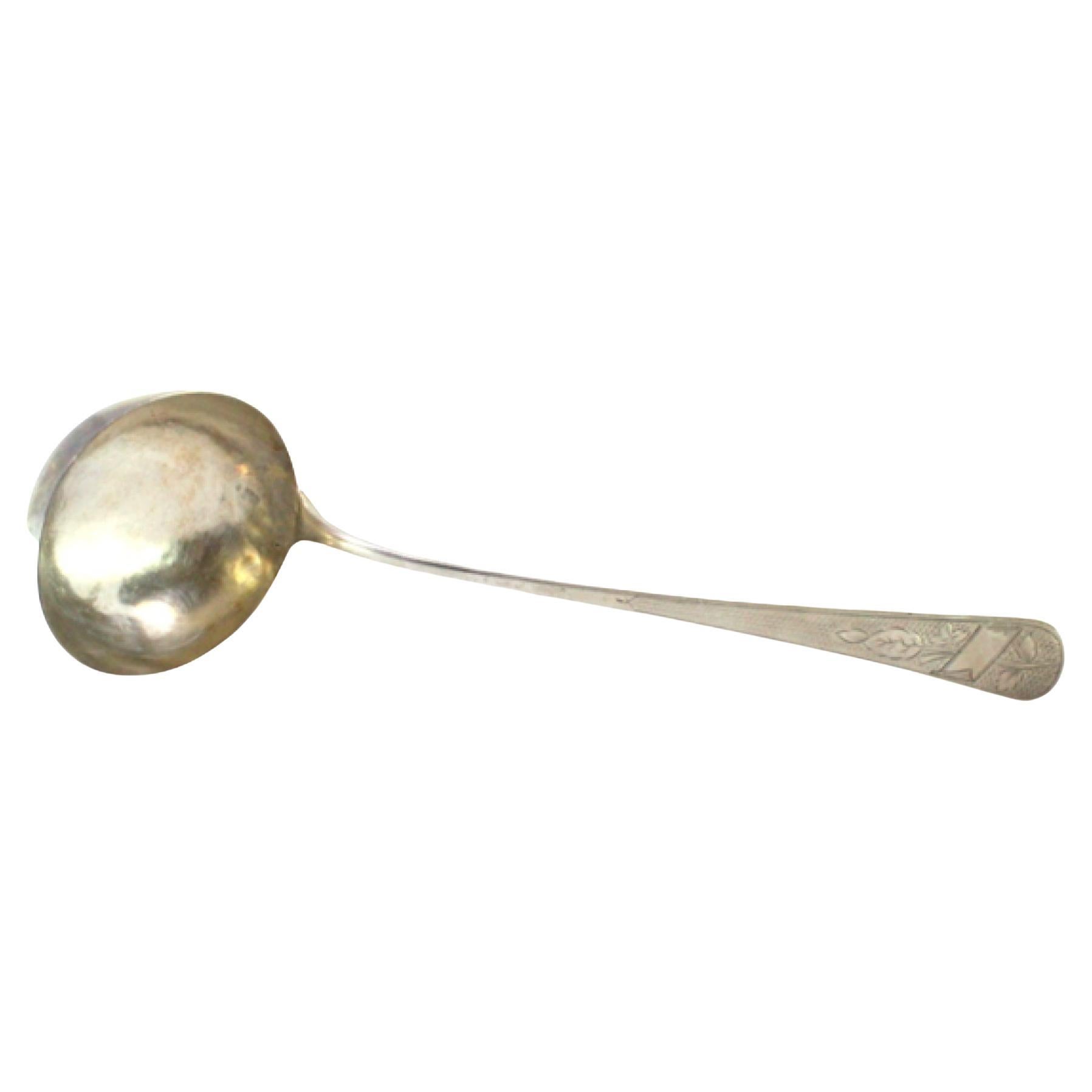 Silver soup ladle with guilloche pattern and floral monogram cartouche