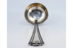 Silver soup ladle with raised friezes along the handle