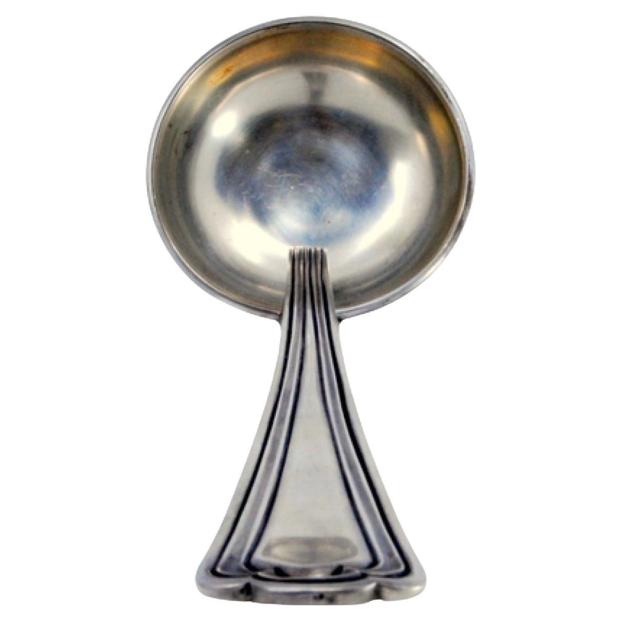 Silver soup ladle with raised friezes along the handle