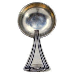 Silver soup ladle with raised friezes along the handle