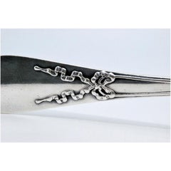 Silver soup ladle with raised loops along the handle