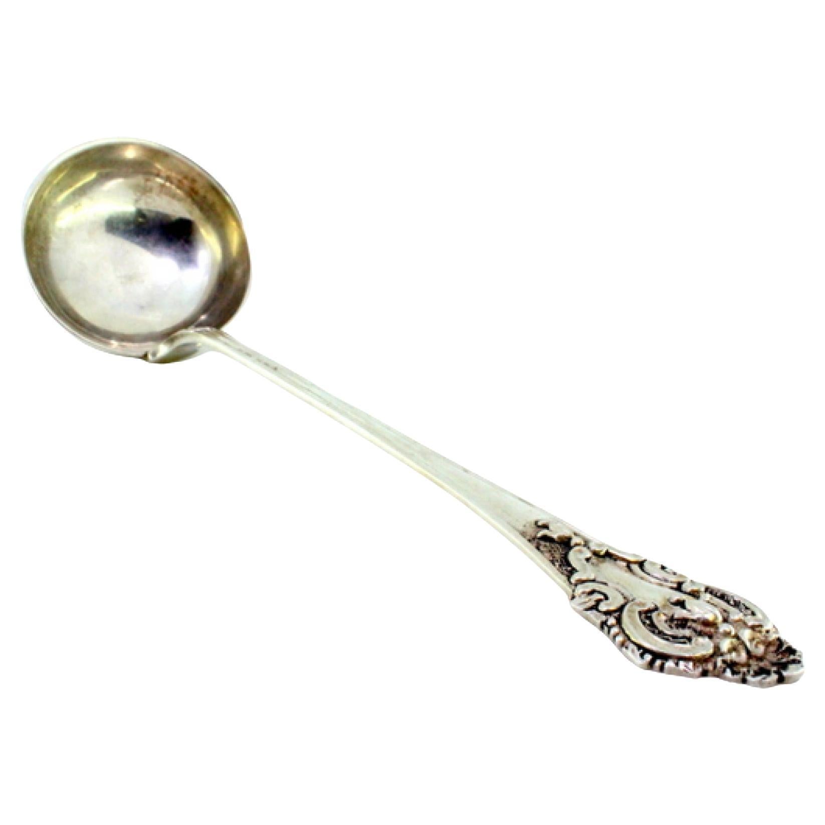 Silver soup ladle with relief friezes and monogram on the handle