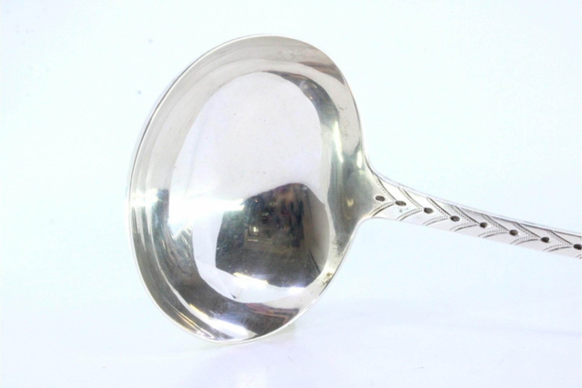 Descripción: Cazo sopero de plata con relieves a lo largo del mango que rodean una tarjeta monograma. Metal: Silver. Origen: Escocés. Marca: León de pie. Peso: 218,97 gramos. Dimensiones: 30,5cmx10,3cm. Contenido: 925/1000. Marca de ensaye: Sí, 1897