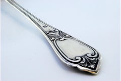 Silver soup ladle with reliefs along the handle surrounding a monogram card