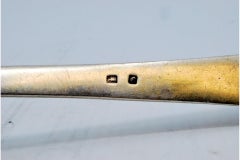 Silver soup ladle with reliefs along the reed-style handle
