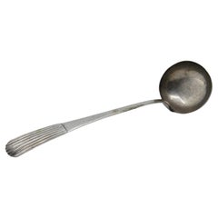 Silver soup ladle with reliefs along the reed-style handle