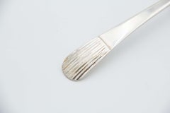 Silver soup ladle with reliefs on the handle