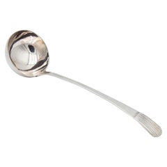 Silver soup ladle with reliefs on the handle