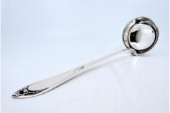 Silver soup ladle with reliefs surrounding a monogram card