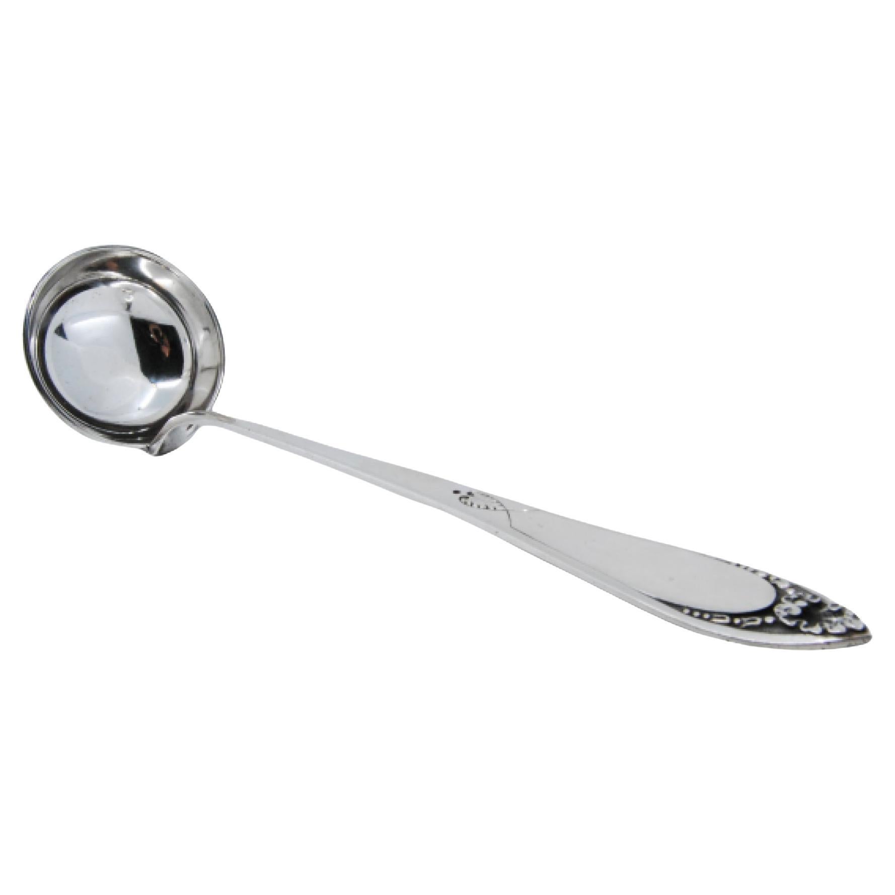 Silver soup ladle with reliefs surrounding a monogram card