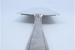 Silver spatula for serving cakes with fine contours on the handle