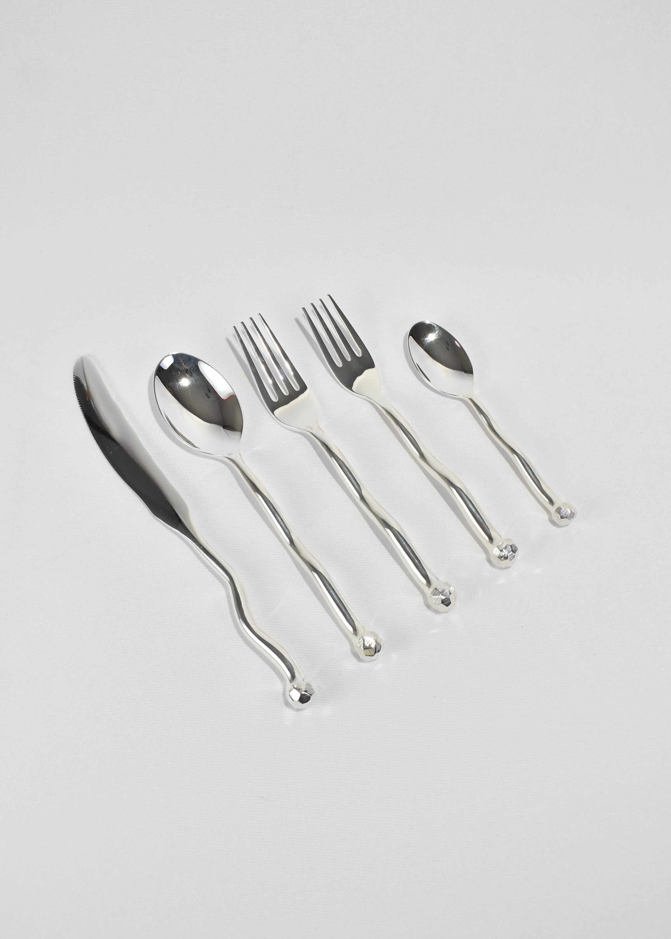The re-issued 5 piece Sphere flatware set in silver plate by Izabel Lam. Each piece features an undulating handle and hammered textured knob on end. Impressed above knob on underside of handle: 'IZABEL LAM'. 

Originally designed in the late 1980s