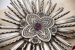Silver splendor w/ reliefs & synthetic stone in cabochon format in the center