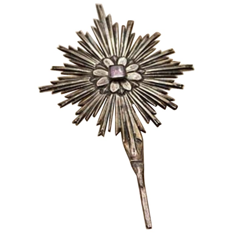 Silver splendor with raised floral motifs and lined red stone