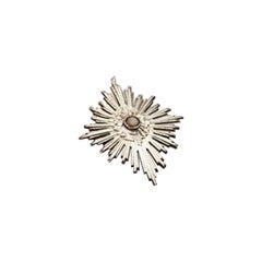 Silver splendor with raised floral motifs surrounding lined stone