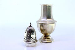 Silver sprinkler in octagonal shape with knob on the lid and grooves on the base