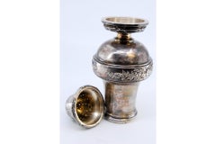 Silver sprinkler with reliefs on the surroundings and circular base