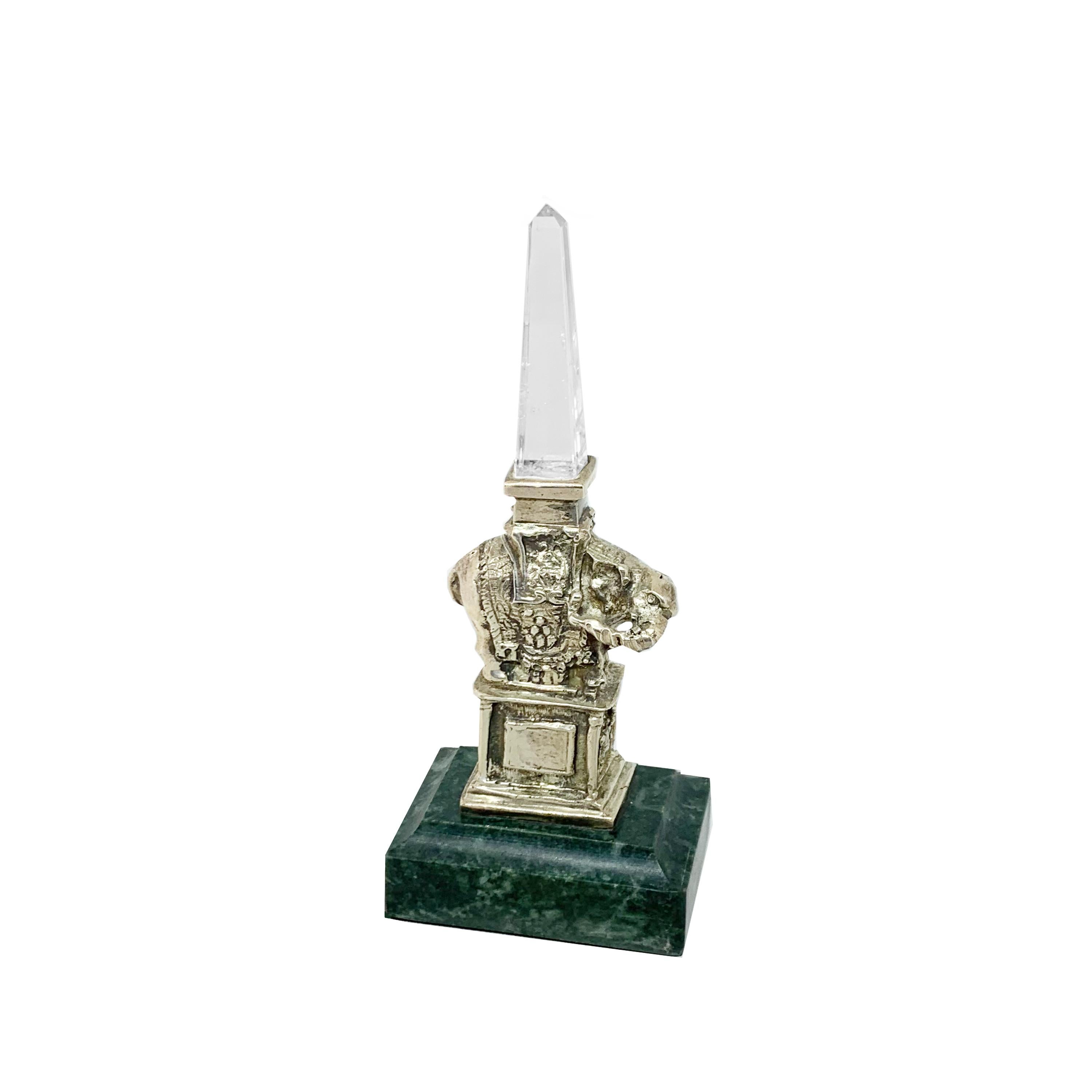 This sterling silver and rock crystal statue was made by our talented Roman artisans, and reproduces a famous monument in Rome.
Adjacent to the Pantheon, in front of the Dominican church “Santa Maria Sopra La Minerva” (St.Mary Over Minerva), lies