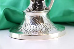 Silver statuette with figure on pedestal and chalice candle holder
