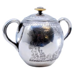 Silver sugar bowl w/ edge engravings of child picking fruit & floral lid