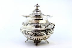 Silver sugar bowl w/ reliefs, applications, 2 handles, knobbed lid & 4 claw feet