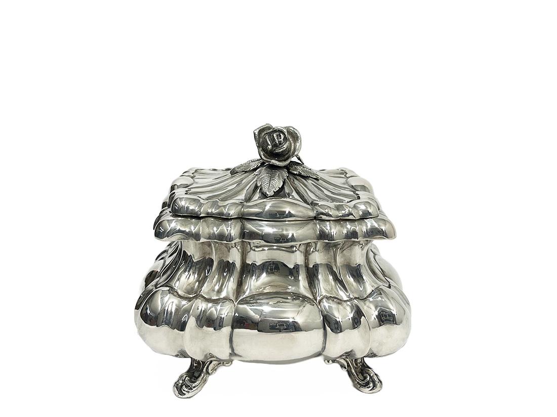 Silver Sugar box, Vienna 1867-1872

An Austrian-Hungary silver sugar box with hinged lid. On the lid a rose with leaves as knob. A rectangular box with beautiful round scalloped body, raised on four legs with scroll leaf pattern. Inside the sugar