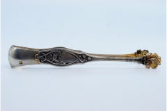 Silver sugar tongs in the shape of claws with raised floral motifs
