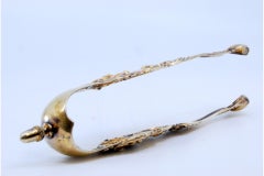 Silver sugar tongs with gold reliefs and applications