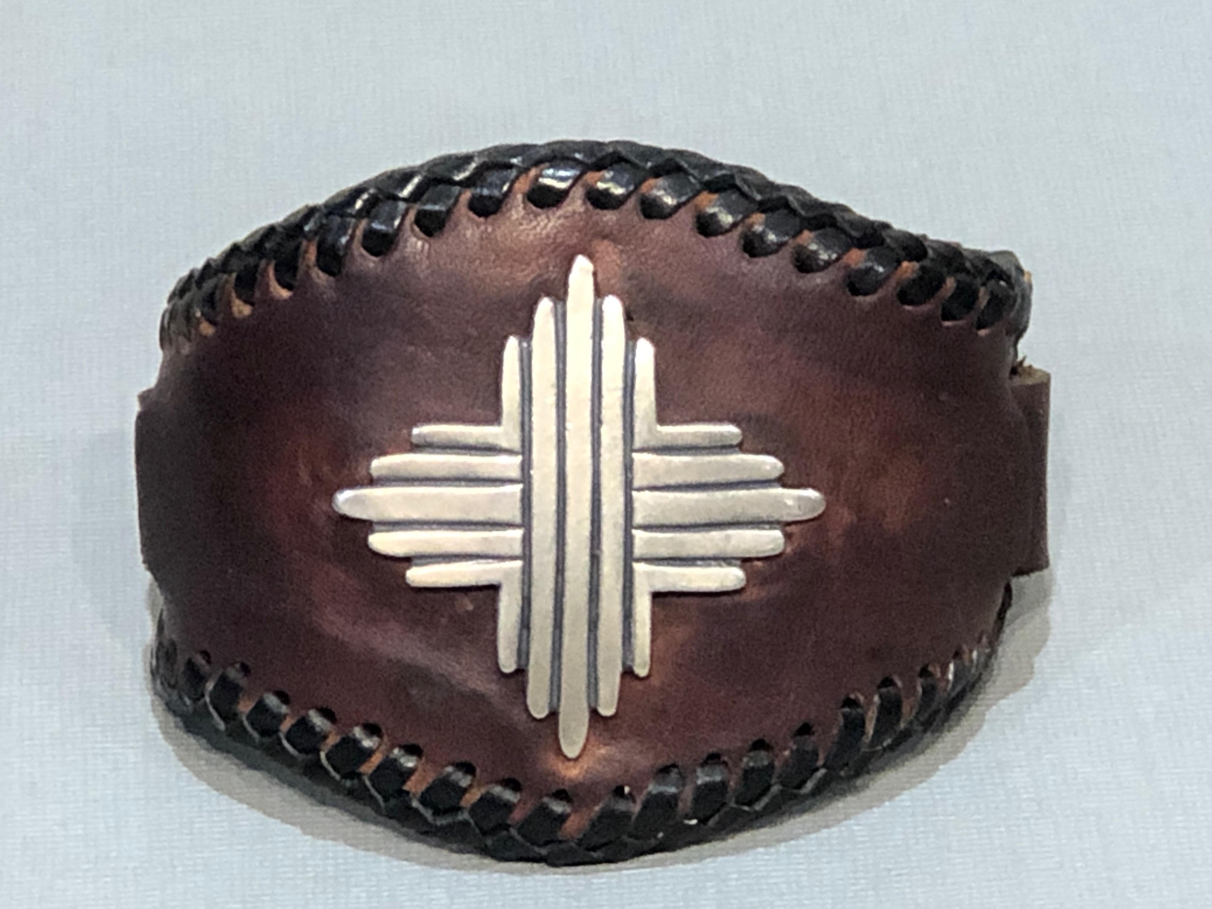 Silver Sun, leather cuff, sterling silver, brown, black, cast silver, Santa Fe

Made in Santa Fe - Glenn Green Galleries