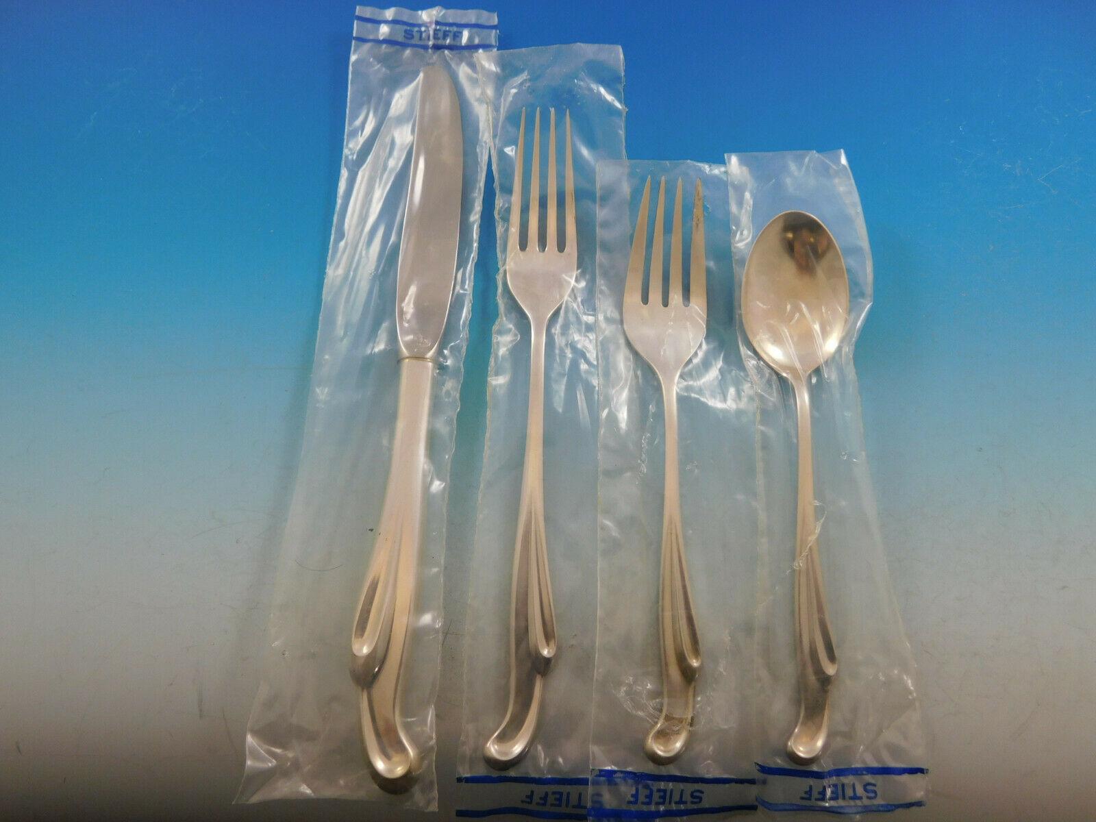 Unused SILVER SURF BY STIEFF sterling silver Flatware set, 48 pieces, circa 1956. The flowing quality of the silver is expressed in this Mid-Century Modern design. This set includes:

12 Knives, 9