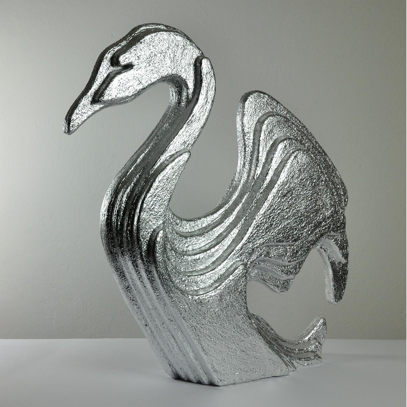 A layered design preciously covered in silver leaf and sinuous, stylized contours mark the sublime silhouette of this artful sculpture shaped like an elegant swan. Finished with plaster applied in relief, it is deftly crafted from extruded