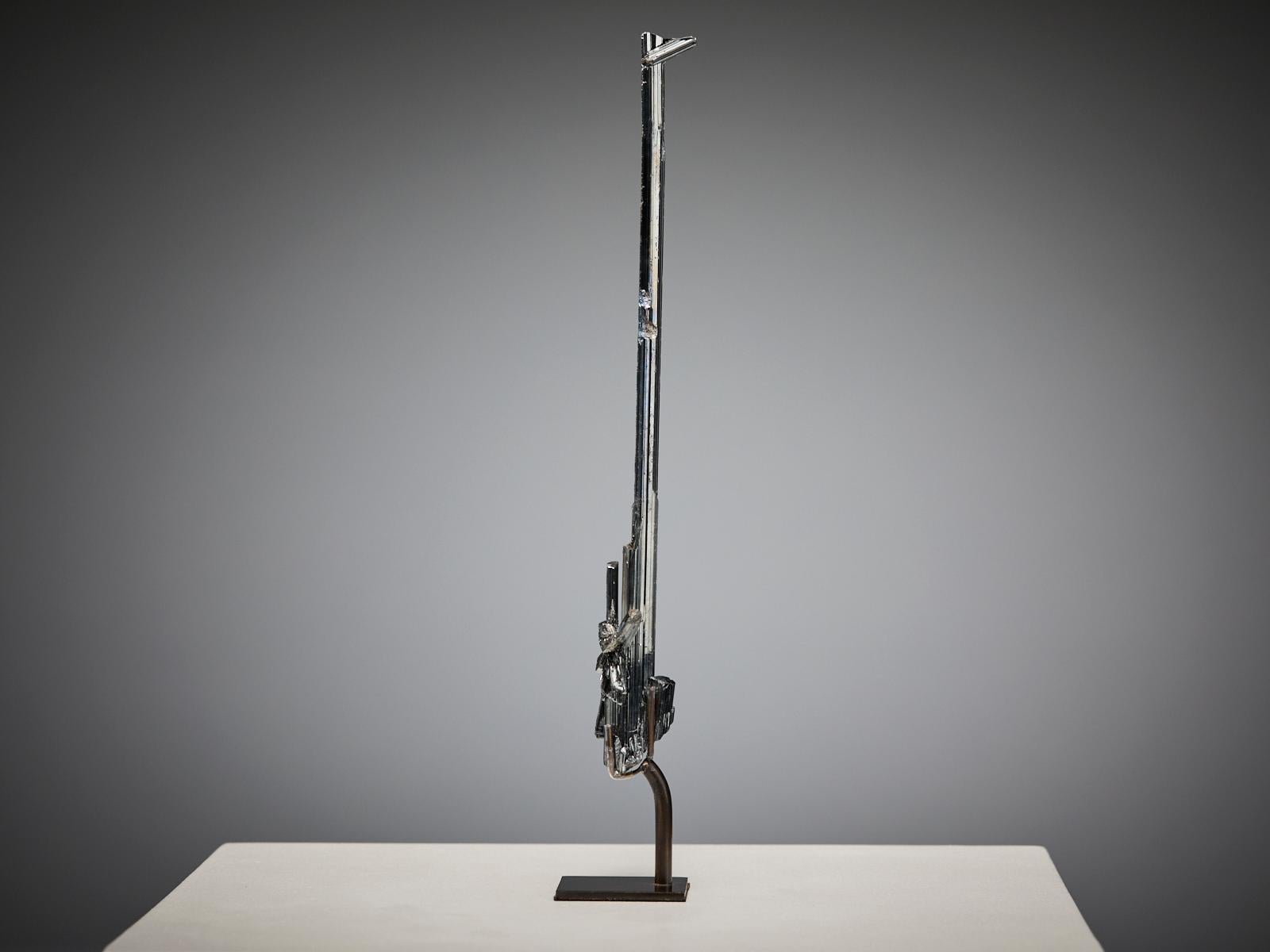 An extraordinary stibnite specimen from China, with a tall, elongated crystal formation that evokes the shape of a silver sword. Its sleek, metallic lustre and refined symmetry give the piece a sculptural, almost hand-crafted presence.

The silvery