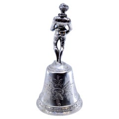 Silver table bell with reliefs and harlequin figure