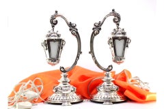 Silver table lamps with suspended globes on relief frames and four-foot bases