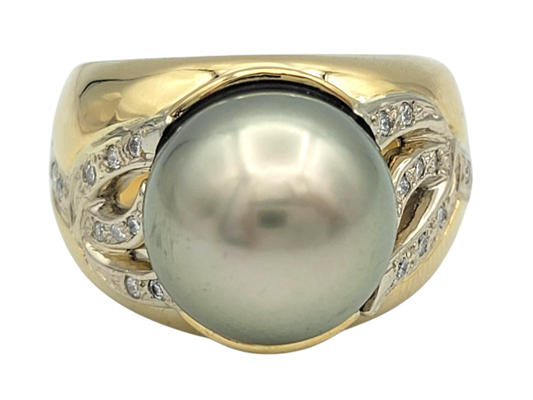Questo anello di grande effetto presenta una luminosa perla di Tahiti in argento incastonata su un'intricata fascia in oro bianco e giallo a 18 carati. La perla grande e rotonda mostra una bellissima e morbida lucentezza verdastra che cambia