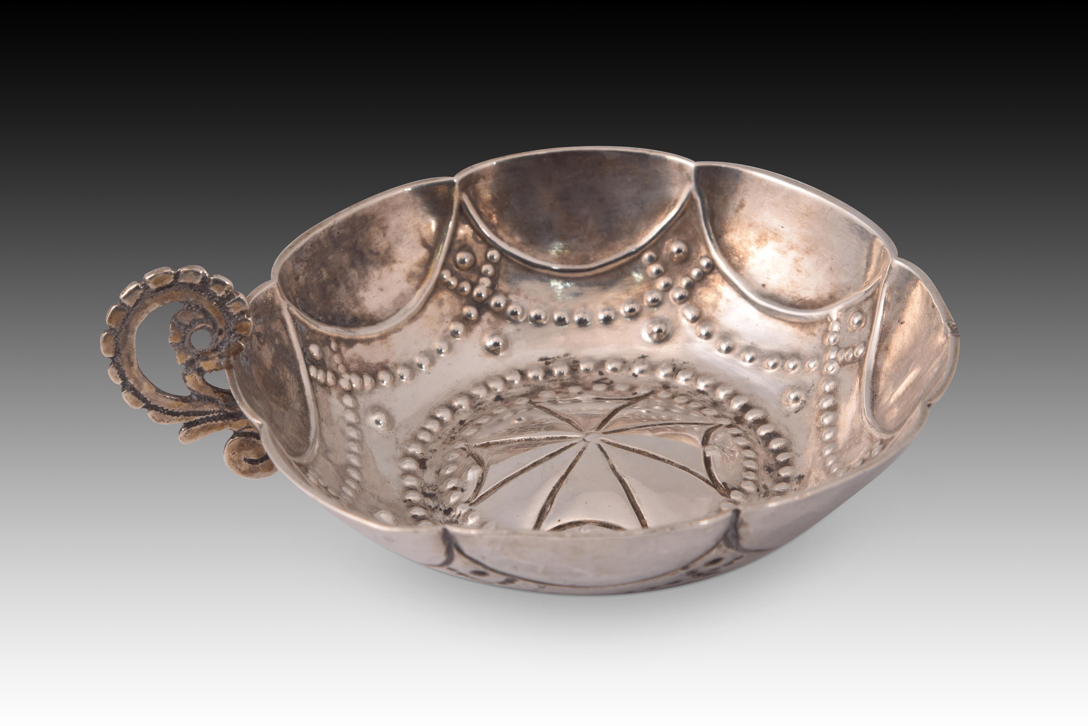Tembladera o catavinos. Silver. Secolo XVIII. 
Manca una maniglia. 
Contenitore noto come catavinos o tembladera (in quanto non ha un piede) realizzato in argento nel suo colore con un manico piatto curvato a forma di 